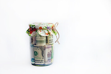 different banknotes in a glass jar covered with a colored napkin, isolated on a white background