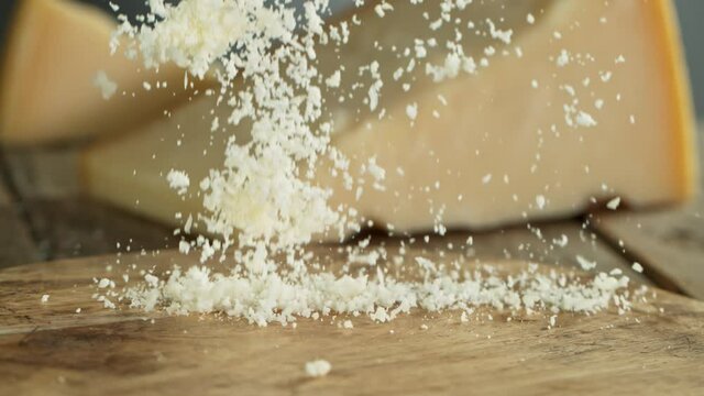 Super Slow Motion Shot of Grated Parmesan Falling on Wooden Board at 1000 fps.