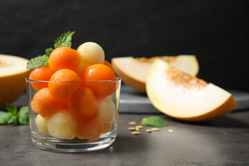 Melon balls and mint in glass on grey table, closeup. Space for text