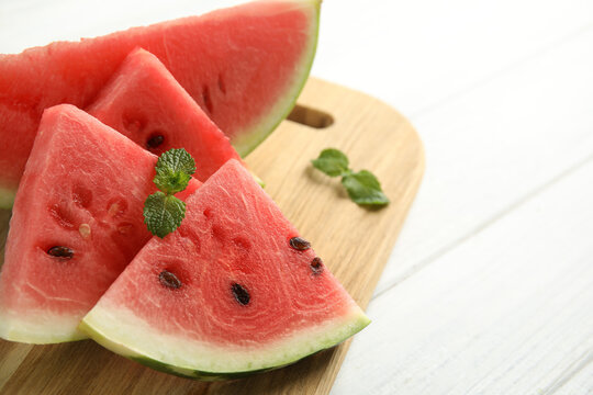 Tasty ripe cut watermelon on white wooden table, closeup