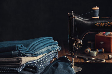 Antique sewing machine and stack of fabrics. Copy space for text.