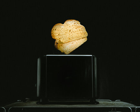 Pan saliendo del tostador con fondo negro minimalista