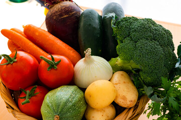 Tomato, green pumpkin, cucumber, beet, onion, potatoe and carrot in a tiny basket