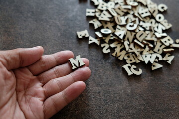 close up of a hand holding M letter.