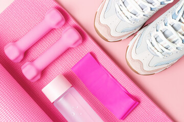 Sports accessories and sneakers on pink background top view.