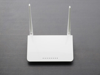 White wireless router on dark wood table.