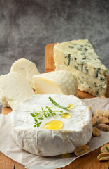 assorted cheeses with honey on a wooden board close-up.