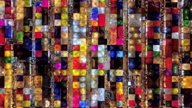 colorful bejeweled like Ratchada night market in Bangkok with people walking and scene rotation