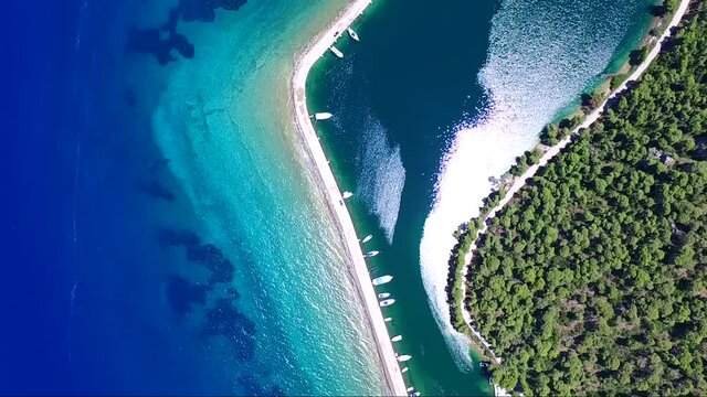 Overhead aerial shot from drone of Mavrolimni bay and fishing port, Greece, with beautiful glimmering and shining sea with tones of blue and turquoise