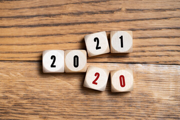 little painter figures and message 2020, 2021 on wooden cubes in front of wooden background