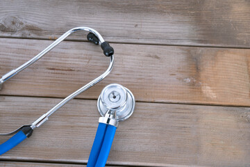 Looking down a stethoscope on a wood grain background