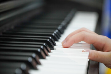 close-up of a happy girl's hand playing the piano in the morning.