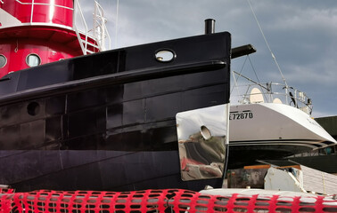 Nave e barca a vela incantiere riflessi acciaio metallo nero rosso riparazione