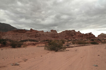 Red canyon. View of the arid desert, red sand, shrubs bushes, sandstone and rocky formation under a...