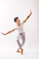 Young Black male ballet dancer showing his skills in the studio.