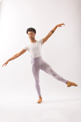 Young Black male ballet dancer showing his skills in the studio.
