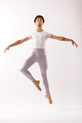 Young Black male ballet dancer showing his skills in the studio.