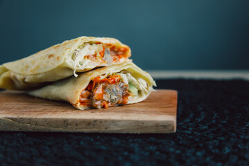 Delicious doner kebab wrapped in tortillas filled with chilli, meat, various vegetables and mayonnaise sauce
