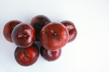 Top view Pile of fresh juicy red plums isolated on white 