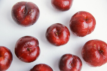 Top view of row of Fresh juicy red plums isolated on white