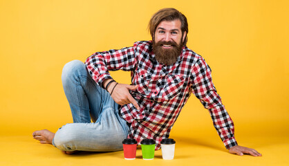 Fototapeta premium lifestyle concept. handsome hipster man with cup of take away coffee. he is taking coffee break. Handsome mature guy drinking from cup. Hold paper cup of coffee or tea