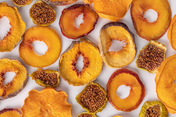 slices of dried persimmon, peach, plum and figs on a white background. dried fruits. eco.