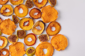 slices of dried persimmon, peach, plum and figs on a white background. dried fruits. eco.