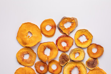 slices of dried persimmon, peach, plum and figs on a white background. dried fruits. eco.