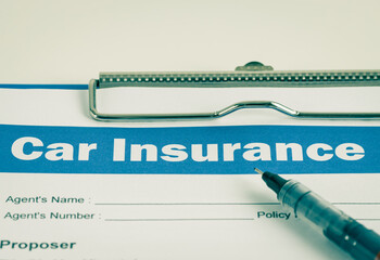 Car Insurance Claim Form or Auto Insurance Document and Pen in Close Up View and Clipboard on White Office Table in Vintage Tone