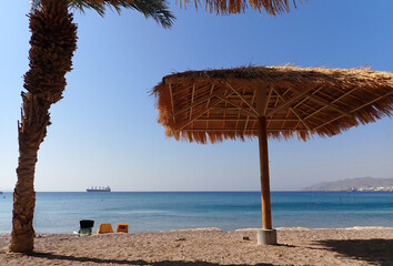 Sandy beach with umbrellas at a shore of the Red Sea, Middle Sea
