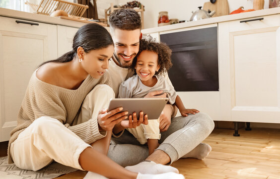 happy multi ethnic family: parents and son using tablet  at home