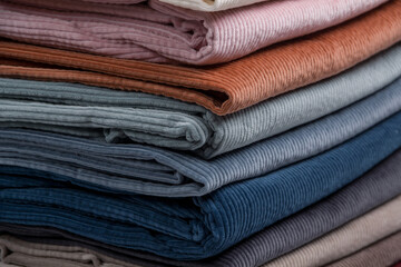 Multicolored fabrics folded in a stack . Multi-colored corduroy textile.  Velvet. - obrazy, fototapety, plakaty