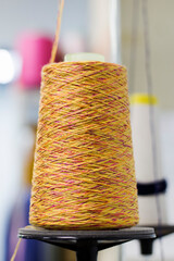 thread in yellow on a modern machine for the connection of the knitted parts