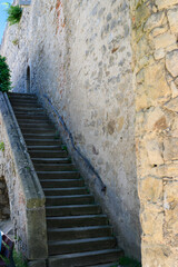 Fototapeta na wymiar Stone castle staircase outside by the wall.