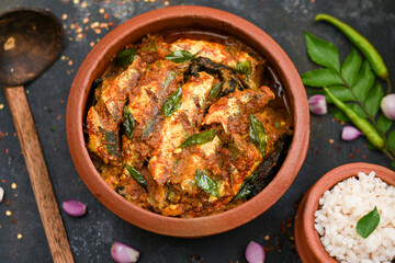 Top view of Sardine fish curry spicy Kerala fish curry and rice India, Indian food with red chili, curry leaf. Asian cuisine. Delicious spicy, Bengali Goan fish curry coconut milk, mango clay pot.