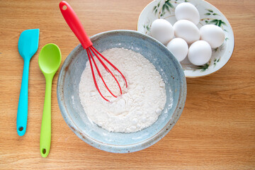 Baking Cooking Ingredients Flour Eggs colorful Kitchen utensils On Bright woody Background. Top View Copy Space. Cookies Pie Or Cake Recipe.