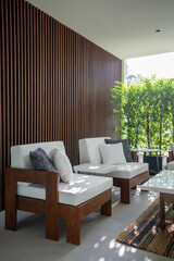 Outdoor seating corner with wood batten background in tree shade  /interior design / outdoor space / copy space