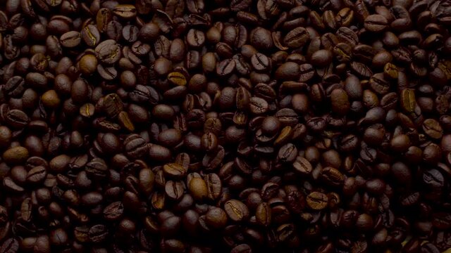 4K Footage. 4096x2304P.Fragrant coffee beans are roasted in a frying pan, smoke comes from coffee beans. The whole composition scrolls slowly around the camera. Scoop stir coffee beans.