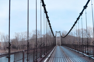 Hinged bridge through the Katun river in Altai . Bridge going into perspective. 