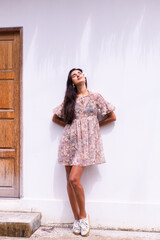 Happy smiling laugh caucasian long hair woman in dress stands on white wall background, holding...