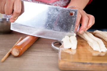 Cut the raw long dough sticks into two with a knife