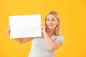 Obraz na płótnie Canvas Woman with blank paper sheet on color background