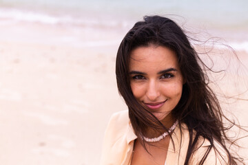 Fototapeta premium Romantic portrait of woman on beach at windy day, sunset warm light. 