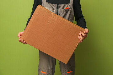 loader holding a cardboard box. a delivery service employee holds a box