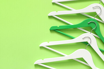 Clothes hangers on color background