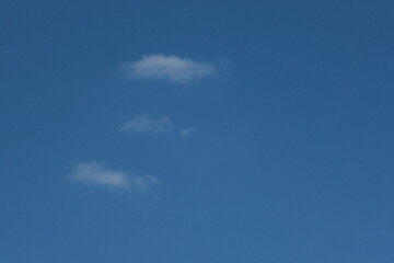 three soft clouds against a blue sky