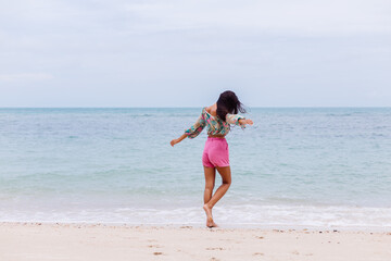 Fototapeta premium Happy woman with long hair in pink shorts enjoy time on beach by sea 