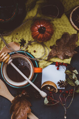 hot tea with honey and cinnamon in an orange Cup autumn atmosphere on a dark background