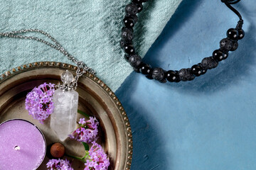 Aromatherapy concept. Lava bracelet, perfume vial, scented candle, vervain flowers, shot from the...