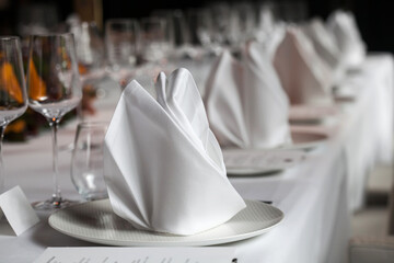 Napkin set up on dinner table in the restaurant.Background blurry.